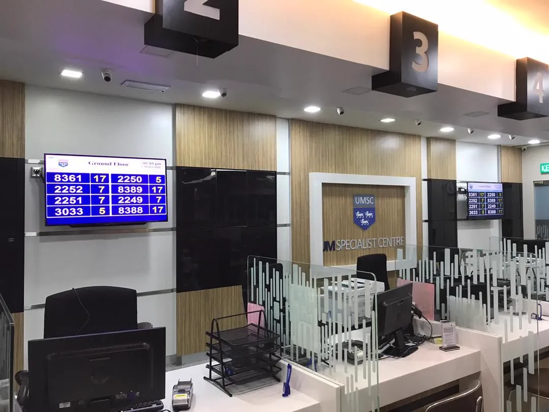 Service counters at UM Specialist Centre with queue number displays